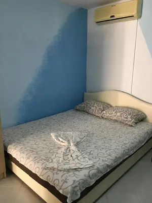 a bed in a room with a blue wall at Sobe Krin - Smestaj Canj in Čanj