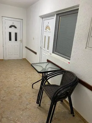 a table and a chair in a room with a door at Sobe Krin - Smestaj Canj in Čanj