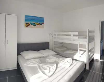 a bedroom with a white bunk bed with a ladder at Lanika Apartments in Ulcinj
