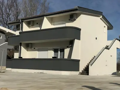 a white house with a black roof at Lanika Apartments in Ulcinj