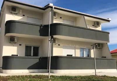 a large white building with a black balcony at Lanika Apartments in Ulcinj