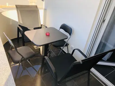 a table and chairs with a red candle on it at Lanika Apartments in Ulcinj
