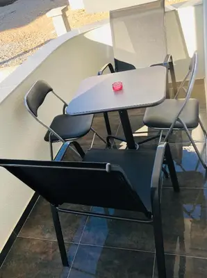 a table and chairs with a red cup on it at Lanika Apartments in Ulcinj