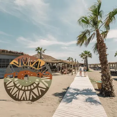 a large clock on the beach with palm trees at Lanika Apartments in Ulcinj