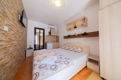 a bedroom with a bed and a brick wall at Azzuro apartments Budva in Budva