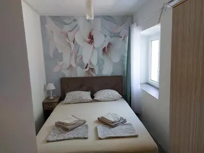 a bedroom with a bed with flowers on the wall at vicky 1 in Kotor