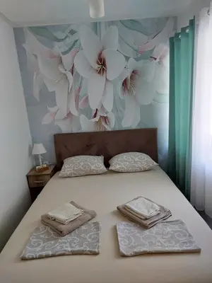 a bed with two towels on it with a flower wall at vicky 1 in Kotor