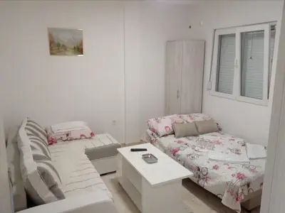 a living room with a couch and a bed at Apartmani M&V in Sutomore