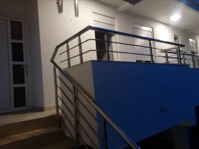 a staircase with a blue railing in a building at Apartmani M&V in Sutomore