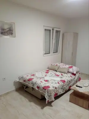 a bed in a white room with a bed sidx sidx sidx at Apartmani M&V in Sutomore