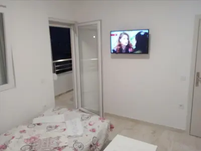a bedroom with a mirror and a tv on the wall at Apartmani M&V in Sutomore