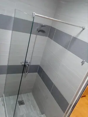 a shower with a glass door in a bathroom at Apartmani M&V in Sutomore