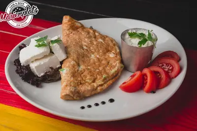 a white plate with food on a table at Hotel Marienplatz Podgorica in Podgorica