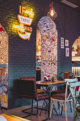 a restaurant with a table and chairs and a brick wall at Hotel Marienplatz Podgorica in Podgorica