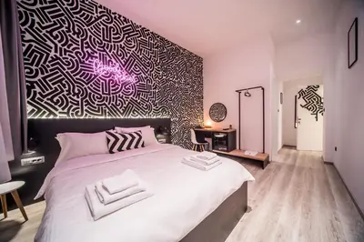 a bedroom with a large bed with a black and white wall at Hotel Marienplatz Podgorica in Podgorica