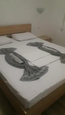 a bed with two blankets on top of it at Dalukos Apartmani in Sutomore