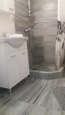 a bathroom with a white sink and a shower at Dalukos Apartmani in Sutomore