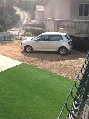a silver car parked in front of a house at Dalukos Apartmani in Sutomore