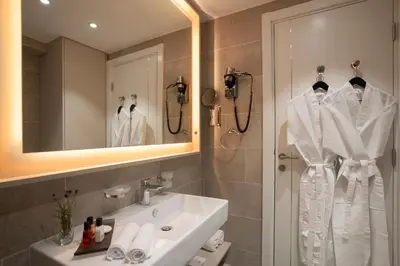 a bathroom with a sink and a shower and a mirror at Fontana Hotel & Gastronomy in Budva
