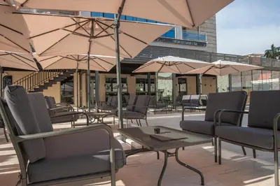 a patio with chairs and tables and umbrellas at Fontana Hotel & Gastronomy in Budva