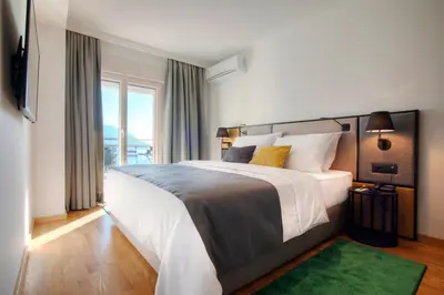 a bedroom with a large bed and a large window at Fontana Hotel & Gastronomy in Budva