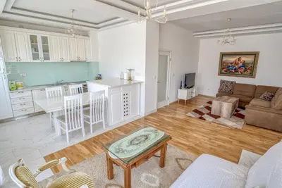 a kitchen and living room with a couch and a table at Apartman Marko in Podgorica