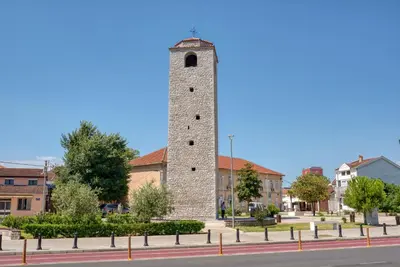 a tall brick tower sitting on the side of a street at Apartman Marko in Podgorica