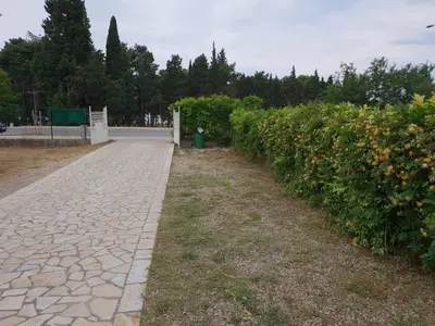 a stone walkway next to a hedge of flowers at Apartments Cindrak in Bar