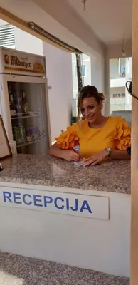 a woman sitting on the counter of a refrigerator at Apartments Cindrak in Bar