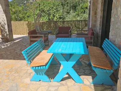 a blue picnic table with two benches and chairs at Stone Villa UK - Dobra Voda in Bar