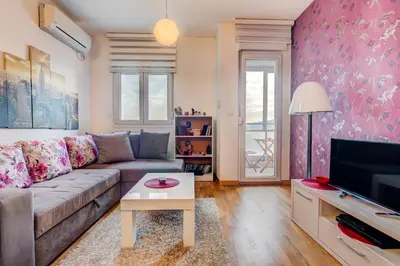 a living room with a couch and a tv at Eureka Apartment in Podgorica