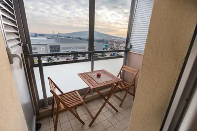 a table and two chairs on a balcony with a view at Eureka Apartment in Podgorica