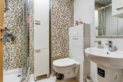 a bathroom with a toilet and a sink and a shower at Eureka Apartment in Podgorica