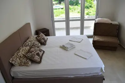 a bed with pillows and a chair in a room at Apartmani Miljevci in Sutomore