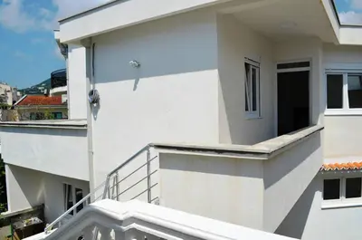 a white apartment building with a balcony at Apartmani Miljevci in Sutomore
