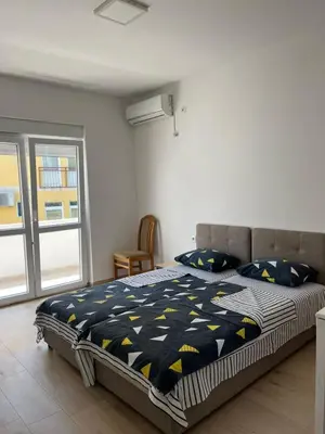 a bedroom with a bed with a black and yellow comforter at Apartmani Miljevci in Sutomore