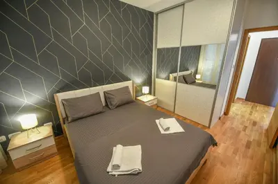 a bedroom with a bed with two towels on it at Apartment Bono Lux City Kvart in Podgorica