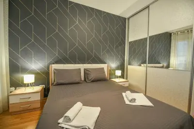 a bedroom with a bed with two towels on it at Apartment Bono Lux City Kvart in Podgorica