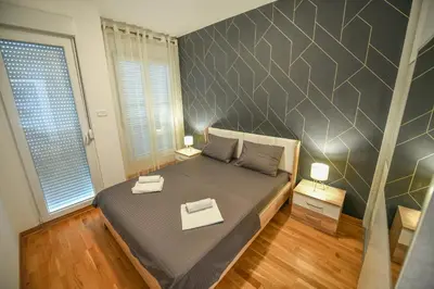 a bedroom with a large bed with two tables on it at Apartment Bono Lux City Kvart in Podgorica