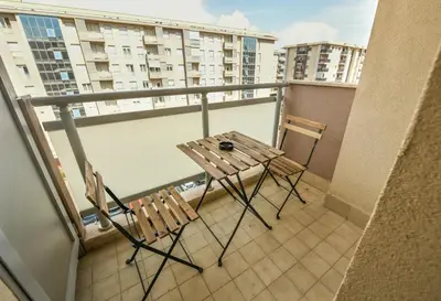 a table and two chairs sitting on a balcony at Apartment Bono Lux City Kvart in Podgorica