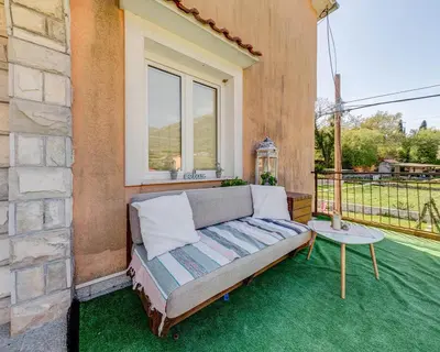 a couch on a balcony with a table at Apartments Pelle in Tivat