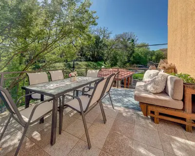 a patio with a table and chairs and a couch at Apartments Pelle in Tivat