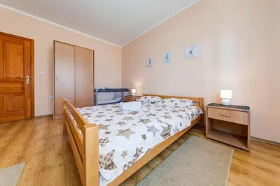 a bedroom with a large bed and a wooden floor at Apartments Pelle in Tivat