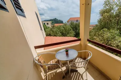 a small table and two chairs on a balcony at Gregovic Family Apartments in Petrovac na Moru