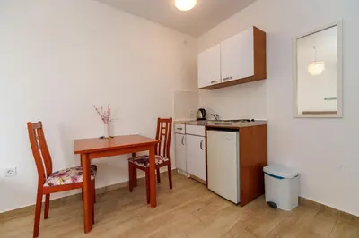 a small kitchen with a table and a table and chairs at Gregovic Family Apartments in Petrovac na Moru
