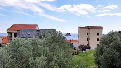 a view of a building and the ocean at Gregovic Family Apartments in Petrovac na Moru