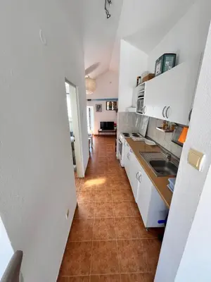 a kitchen with white cabinets and a tile floor at Apartments LIDO Petrovac in Petrovac na Moru