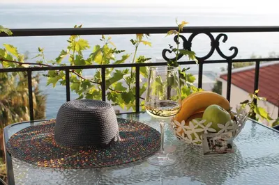 a table with a hat and a glass of wine at Apartmani Kasija in Dobra Voda