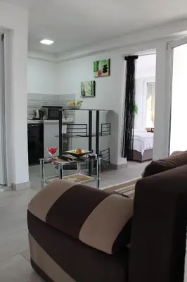 a living room with a couch and a kitchen at Apartmani Kasija in Dobra Voda