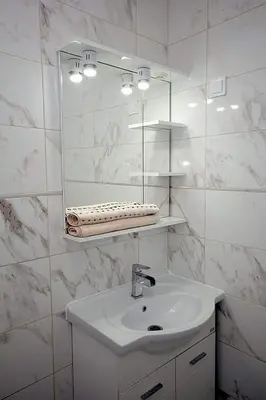 a white bathroom with a sink and a mirror at Apartmani Kasija in Dobra Voda